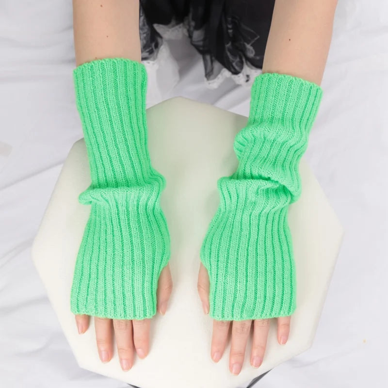 Close-up of stylish women's long fingerless gloves from PressureDen.store, cozy winter arm sleeves with goth and punk fashion details.