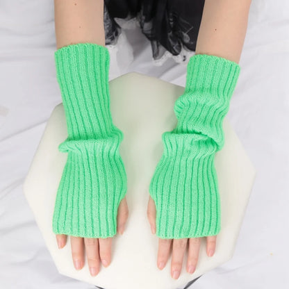 Close-up of stylish women's long fingerless gloves from PressureDen.store, cozy winter arm sleeves with goth and punk fashion details.