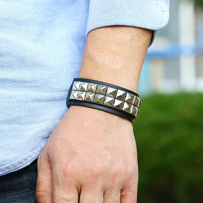 Gothic punk black leather rivet cuff bracelet for men and women with metal studs and adjustable strap.