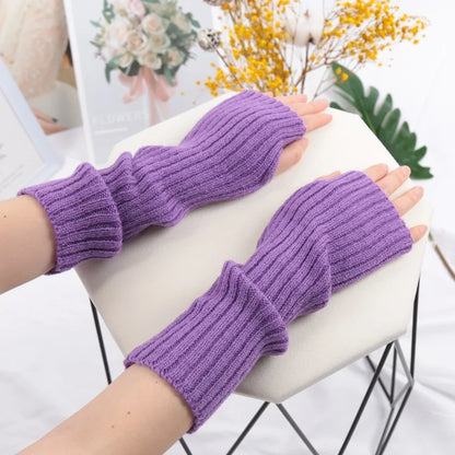 Long black fingerless gloves for women from PressureDen.store, cozy winter arm sleeves with goth and punk style.