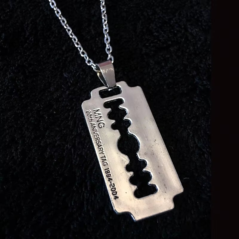 Y2K aesthetic razor blade pendant necklace by PressureDen.store featuring edgy vintage punk goth grunge jewelry for men and women.