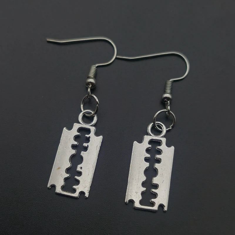 Edgy razor blade earrings for men and women featuring a 90s grunge goth punk aesthetic, showcasing metal jewelry style.