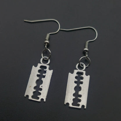 Edgy razor blade earrings for men and women featuring 90s grunge goth punk aesthetic jewelry with metallic finish.