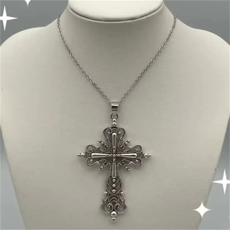 Gothic cross pendant necklace with dark punk style, featuring intricate design, worn by a person with black clothing and accessories.